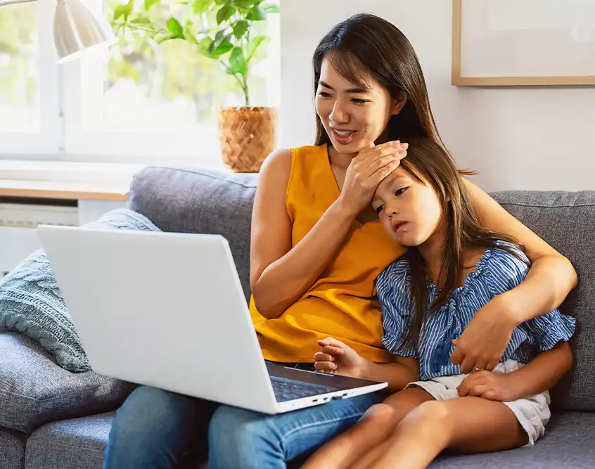 Parent and child on a video visit with a doctor from home