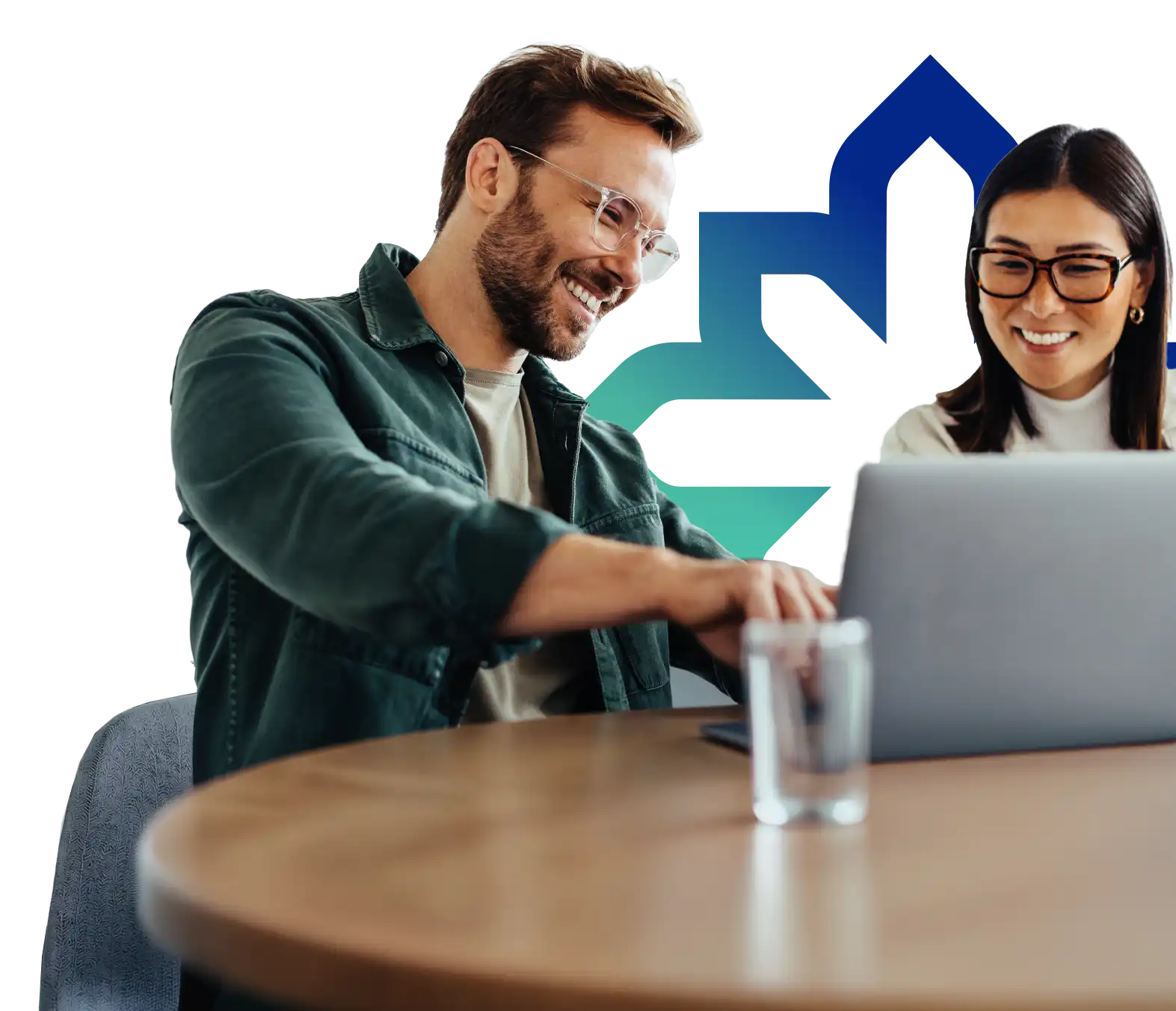 Two business colleagues smiling while reviewing information together on a laptop