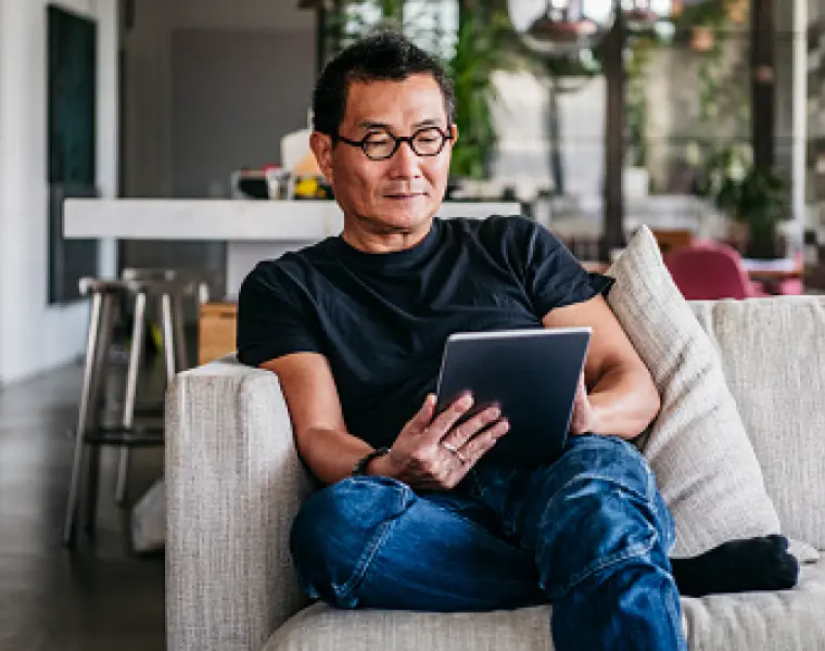 Man relaxing on couch with tablet