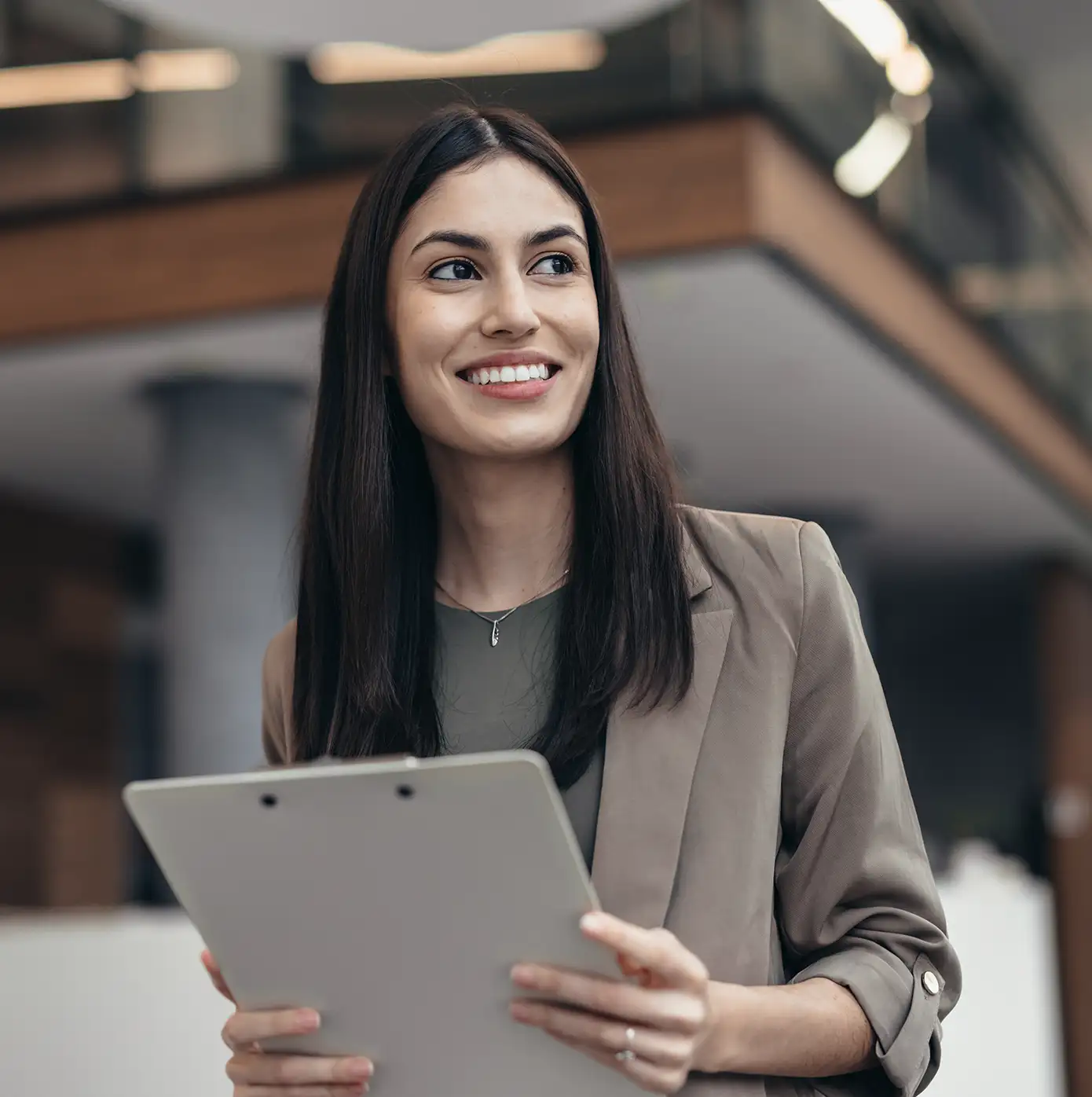 Business professional reviewing documents on a clipboard in a modern office