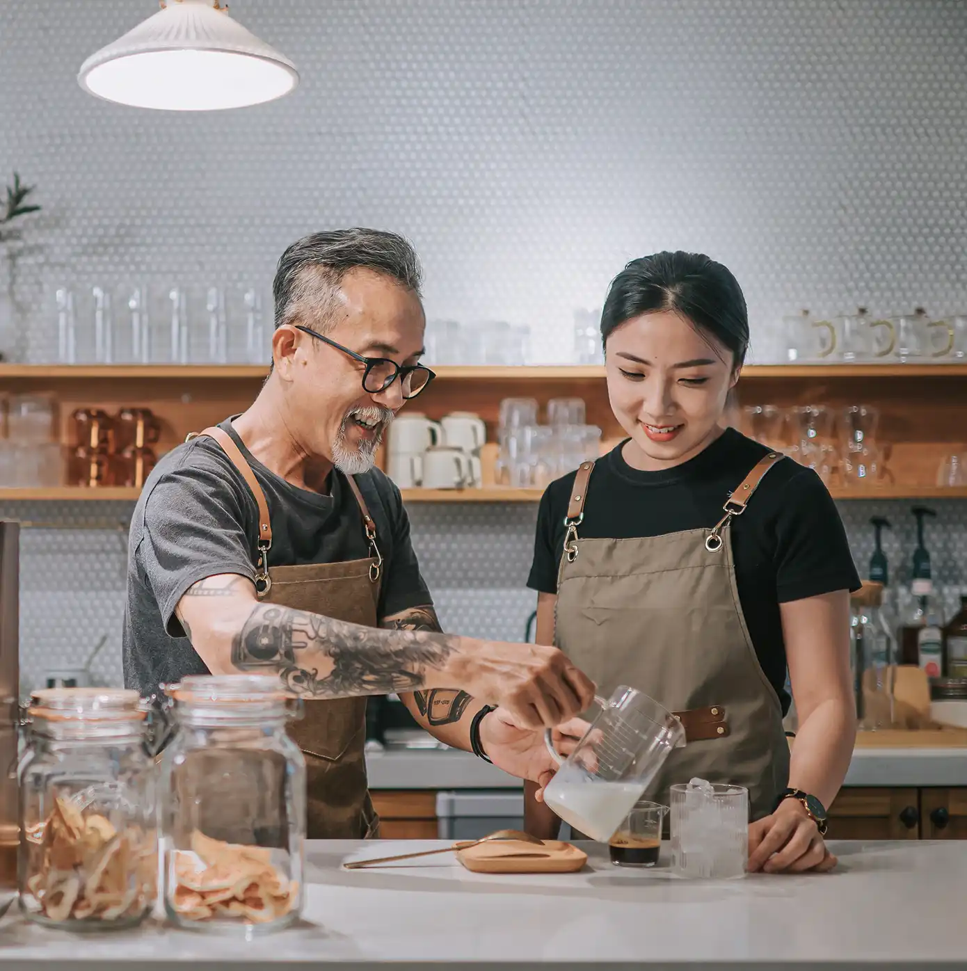Two small business coffee shop employees preparing a drink together