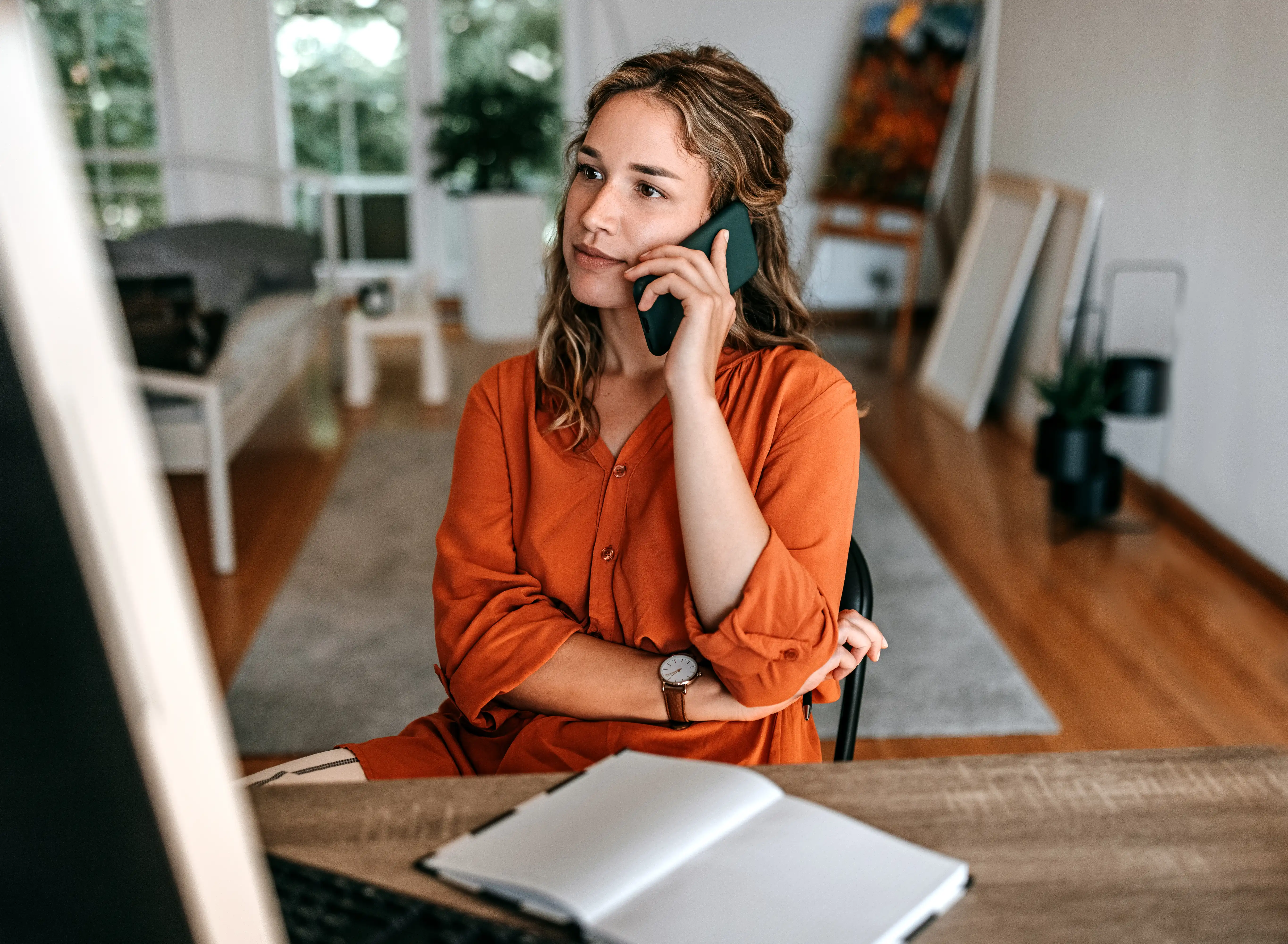 Woman on the phone while working at her desk at home
