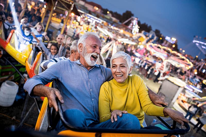 Senior couple rides roller coaster ride.